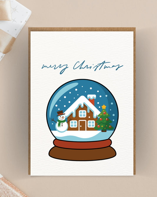 Kerstkaart met sneeuwbol winterhuisje