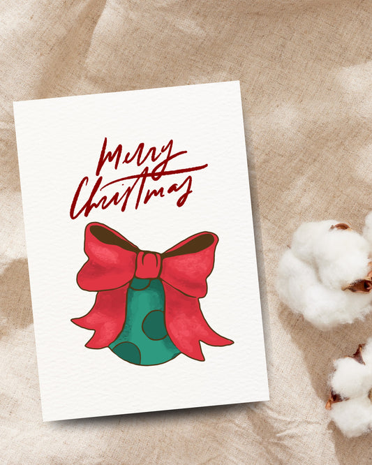 Kerstkaart met kerstbal en strik