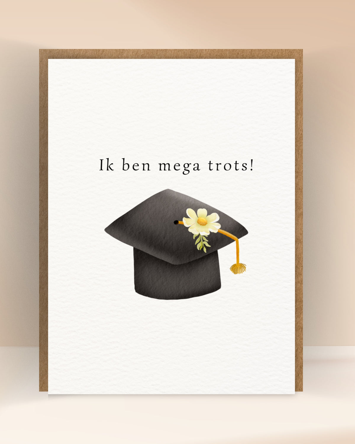 Afstudeerkaart met de tekst ‘Ik ben mega trots!’ en een zwarte afstudeerhoed met witte bloem