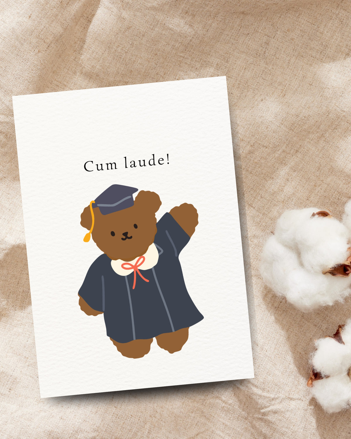Afstudeerkaart met de tekst ‘Cum laude!’ en een bruine beer in toga en afstudeerhoed